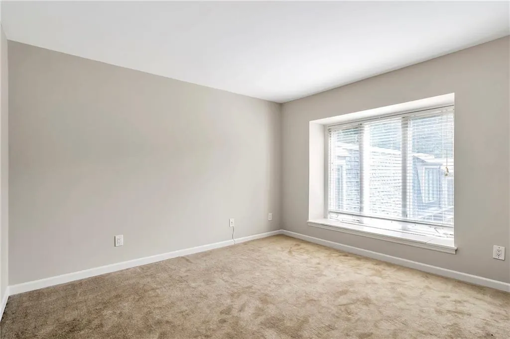 Spare room featuring carpet flooring and baseboards