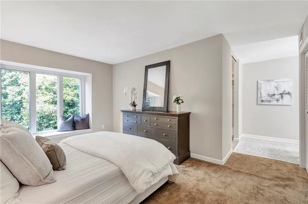 Bedroom featuring light carpet and baseboards