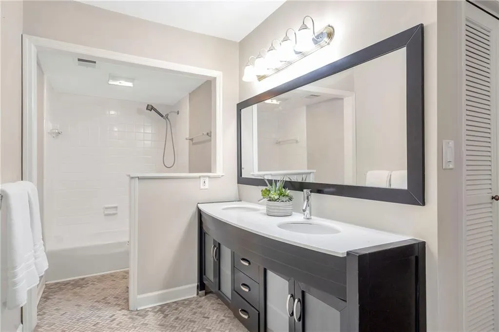 Bathroom featuring double vanity, shower / bathtub combination, and a closet
