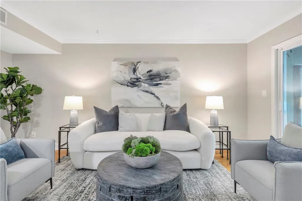 Living room with wood finished floors and ornamental molding