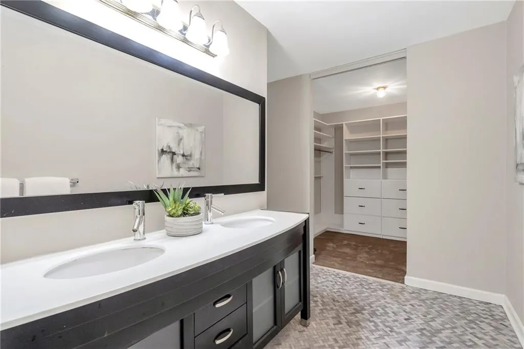 Full bath featuring double vanity and a walk in closet