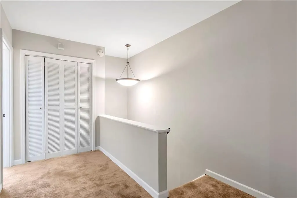 Hallway featuring an upstairs landing and carpet floors