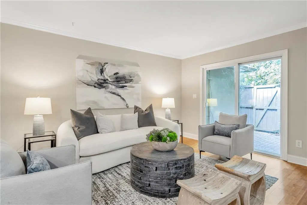 Living area with crown molding and light wood-style floors