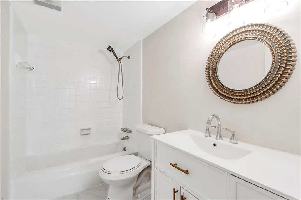 Full bath with bathtub / shower combination, vanity, and marble look tiles
