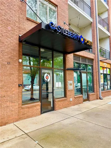 Brick exterior building featuring a prominent entrance with a dark canopy and illuminated signage