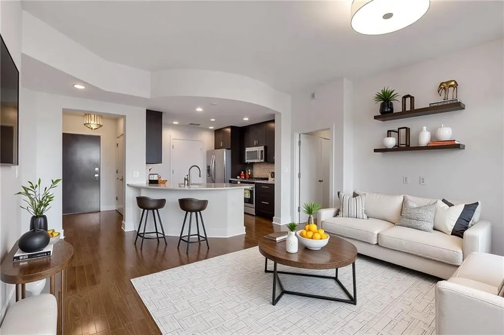 Living room with dark wood finished floors, recessed lighting, and baseboards