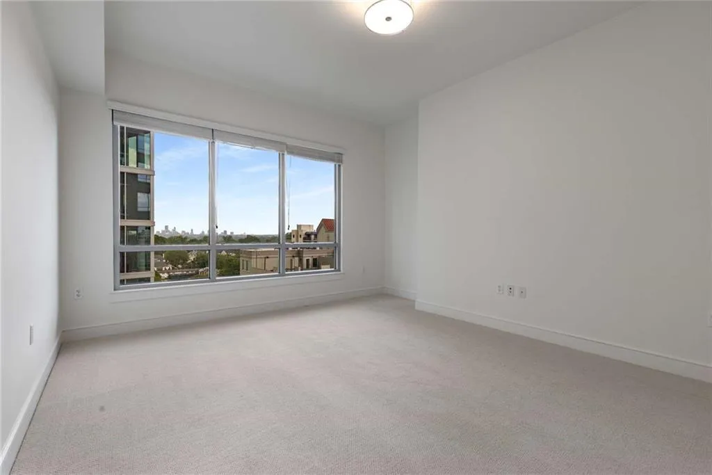 Empty room featuring light colored carpet and baseboards