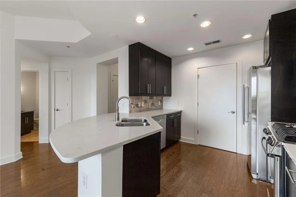Kitchen with a sink, appliances with stainless steel finishes, visible vents, a peninsula, and a skylight