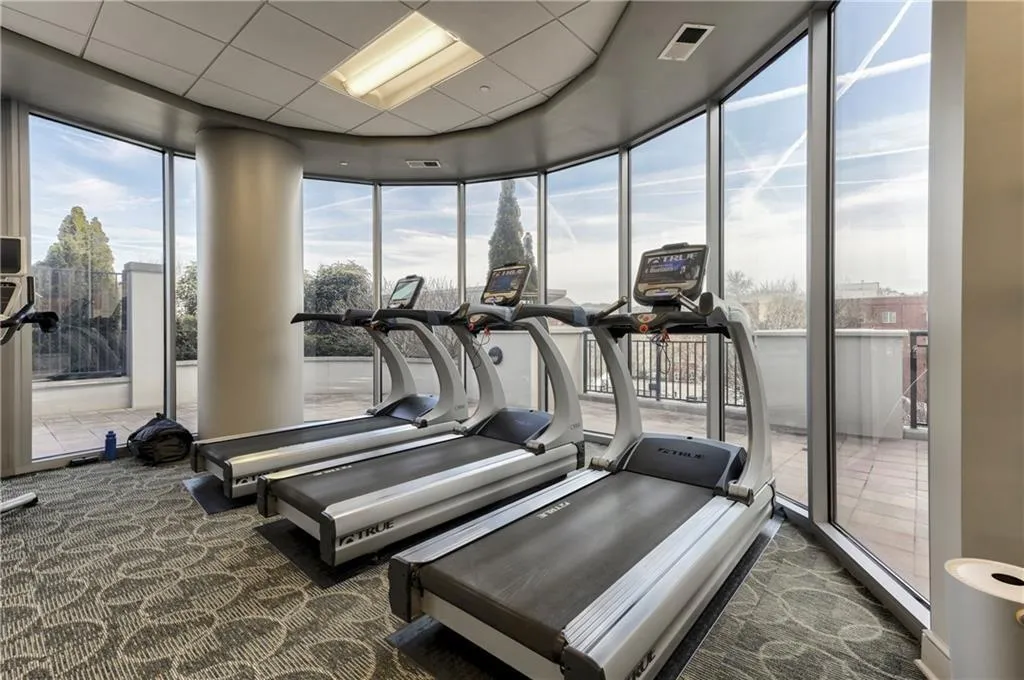 Workout area featuring floor to ceiling windows, visible vents, carpet flooring, and a drop ceiling