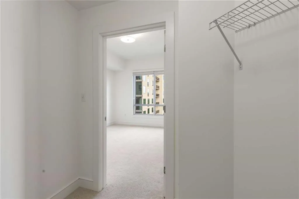 Hall featuring light carpet and baseboards