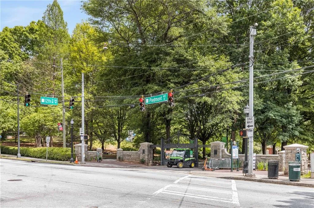 View of road featuring traffic lights, sidewalks, traffic signs, and curbs