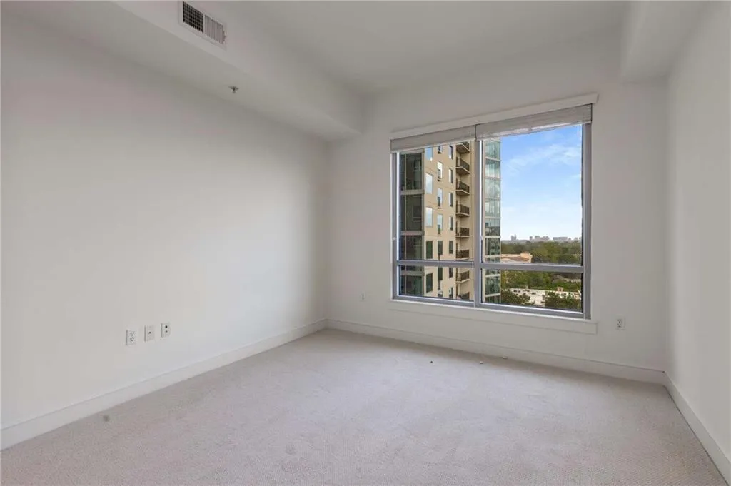Carpeted empty room featuring visible vents and baseboards