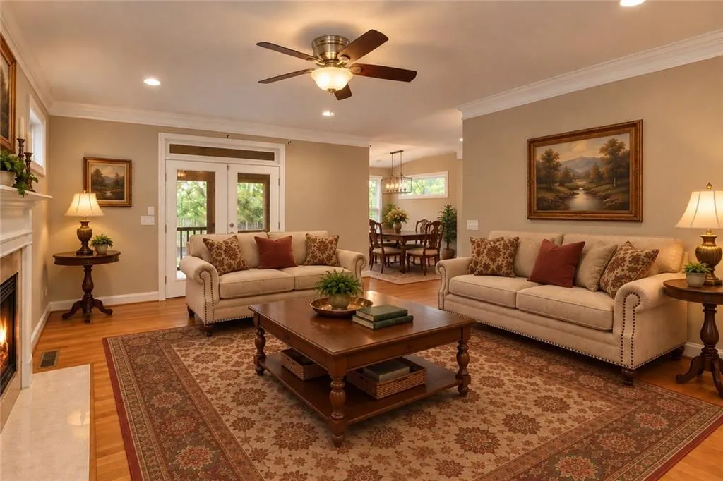 Hardwood flooring, recessed lighting, ceiling fan, crown molding, and a fireplace with a mantel