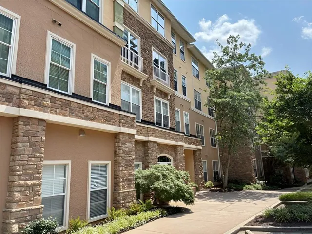 Multi-story exterior with stucco and stacked stone accents