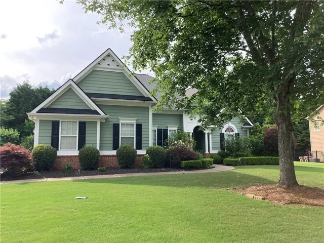 Charming cottage-style home featuring a gabled roofline with dual peaks, horizontal board-and-batten siding in soft gray tones, and classic white trim
