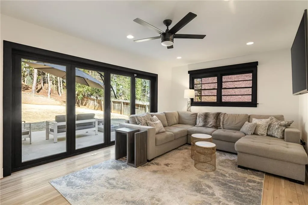 Spacious living area featuring wood-finish flooring, recessed lighting, and a ceiling fan