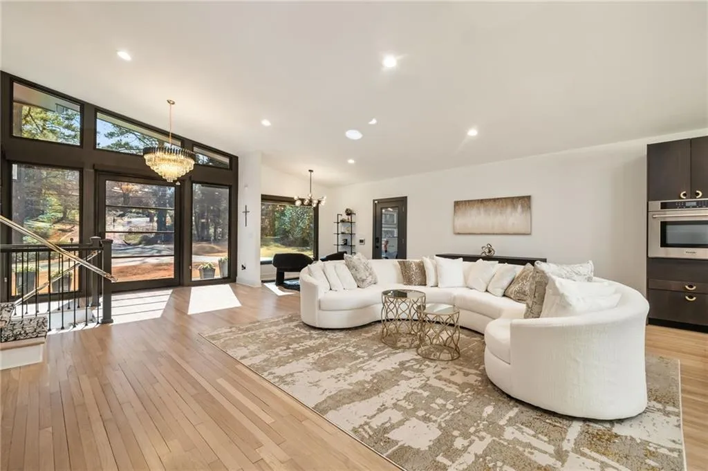 Hardwood flooring throughout, vaulted ceiling, recessed lighting, and a crystal chandelier