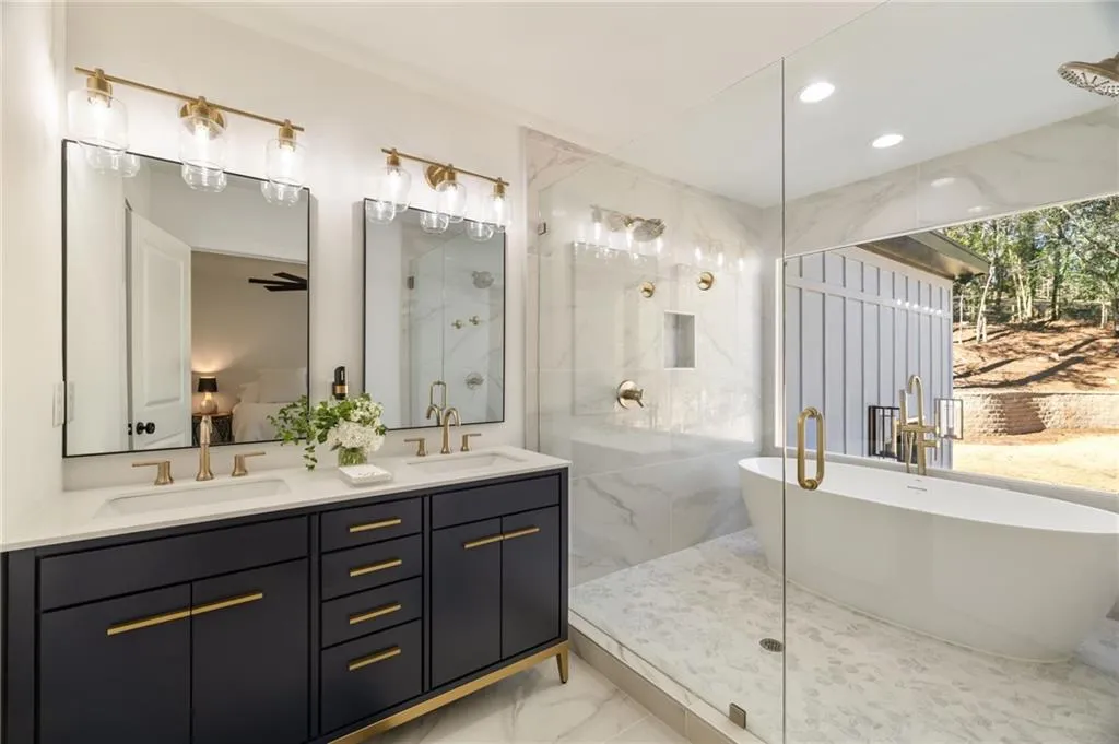 Dual vanity with white countertops, undermount sinks, and gold-finish fixtures