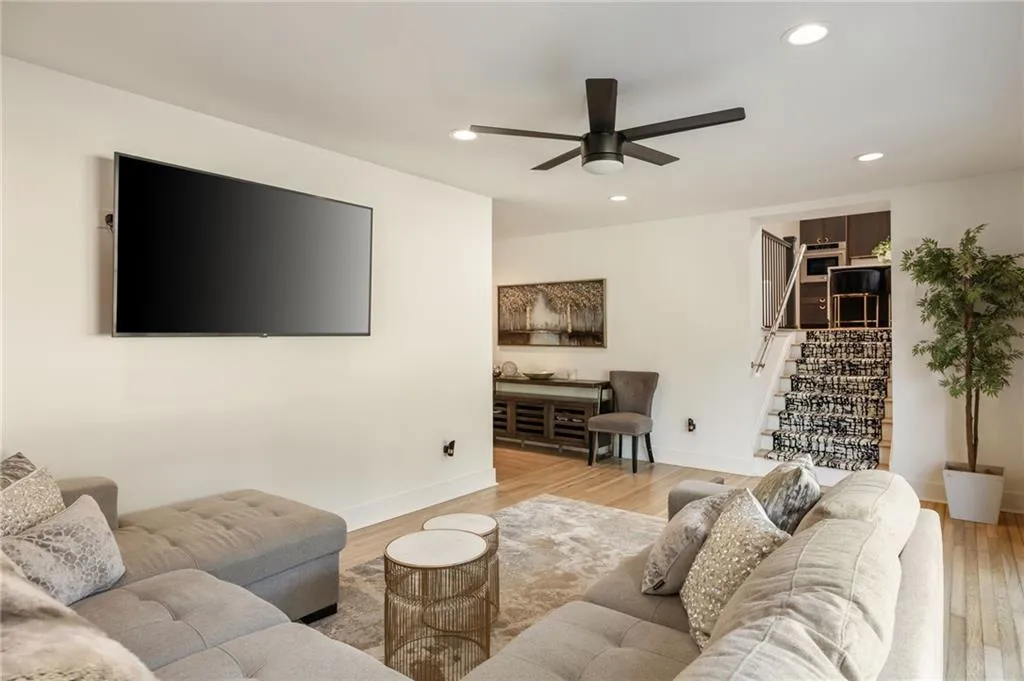Recessed lighting, wood-finish flooring, ceiling fan, carpeted staircase, and built-in shelving
