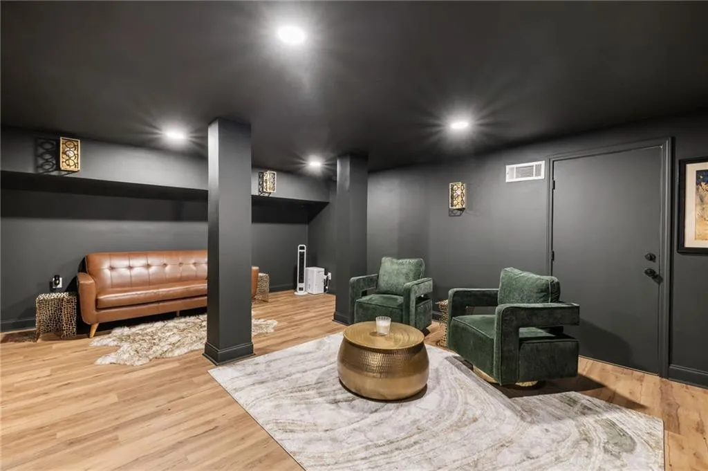 Recessed ceiling lighting, wood-finish flooring, dark-painted walls, and integrated wall shelving