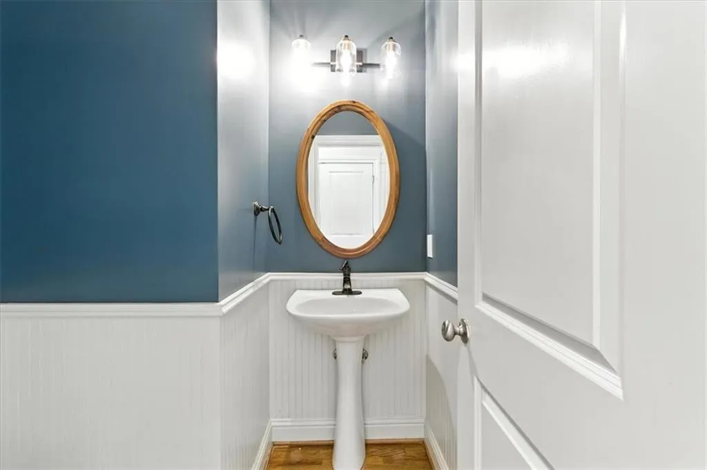 Bathroom featuring a wainscoted wall and wood finished floors