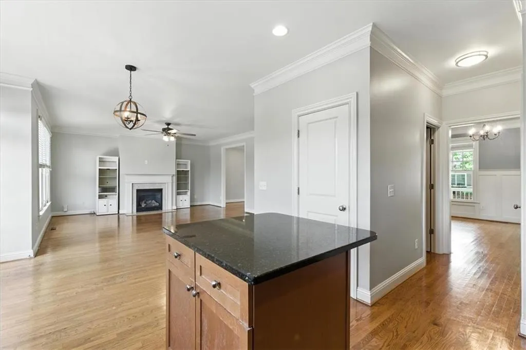 Kitchen featuring ornamental molding, a chandelier, light wood-style flooring, and a fireplace