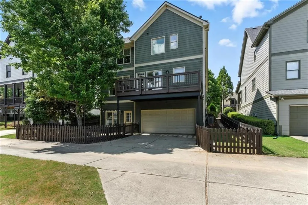 View of front of property with a garage, driveway, and a balcony