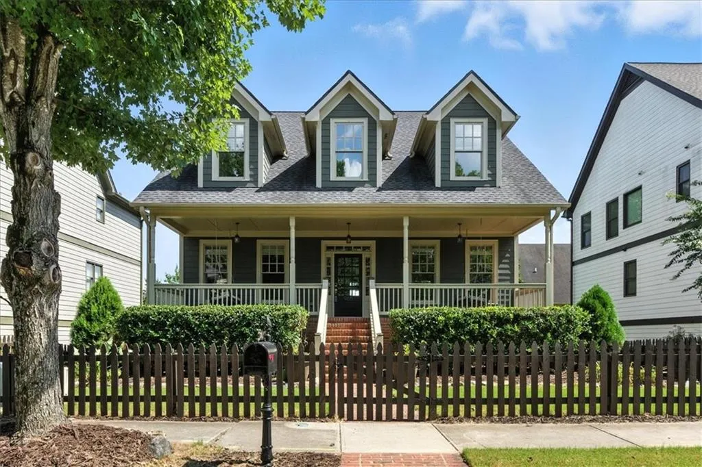 Cape cod house featuring a porch, a shingled roof, and a fenced front yard