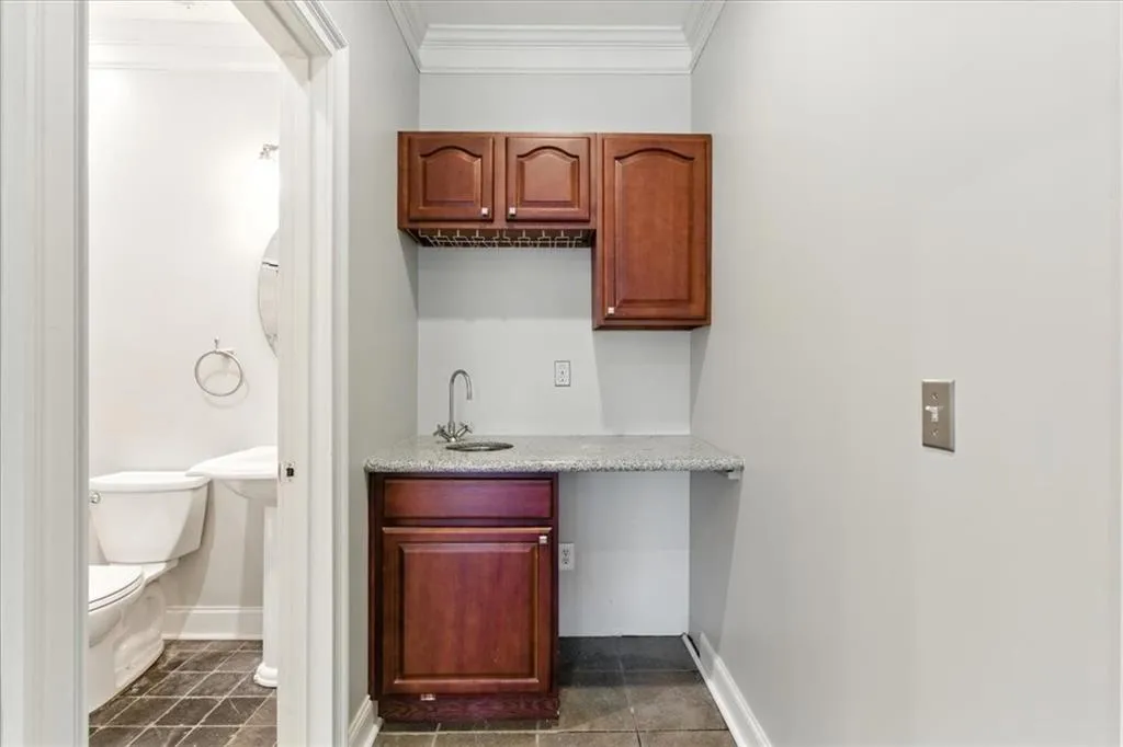 Bar featuring ornamental molding and dark tile patterned floors