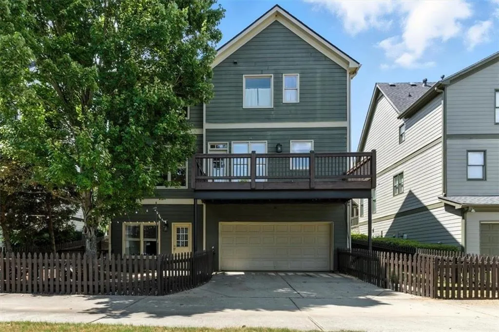 Traditional-style house featuring an attached garage, driveway, and a balcony