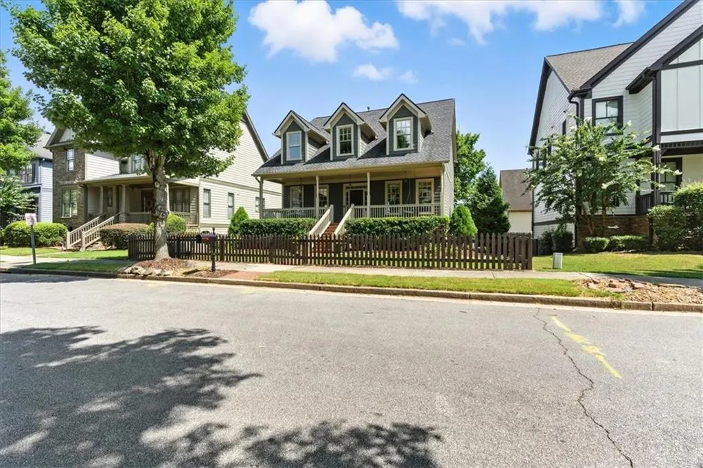 Cape cod house featuring covered porch, a fenced front yard, and stairway