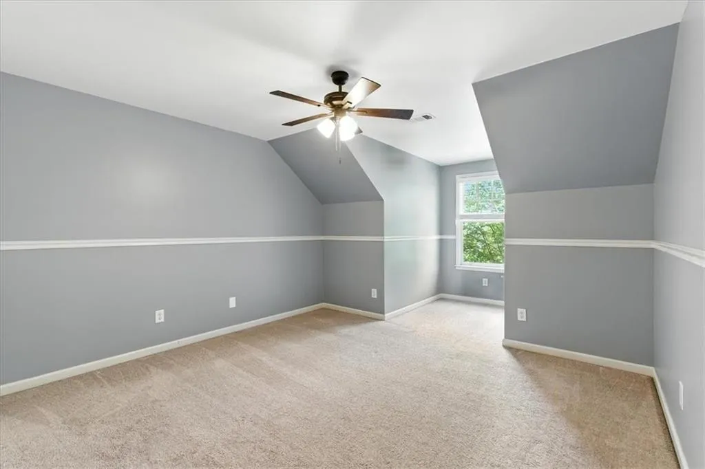 Bonus room featuring carpet, vaulted ceiling, and ceiling fan