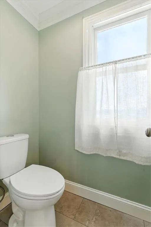 Bathroom with ornamental molding and tile patterned floors