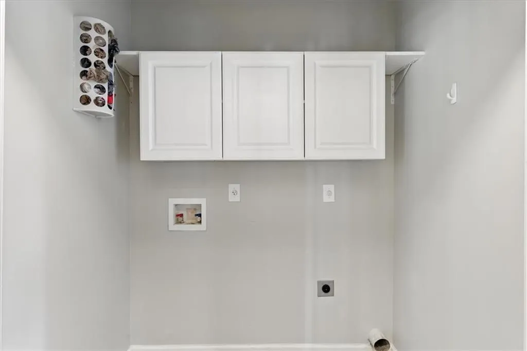 Laundry room featuring electric dryer hookup, washer hookup, and cabinet space