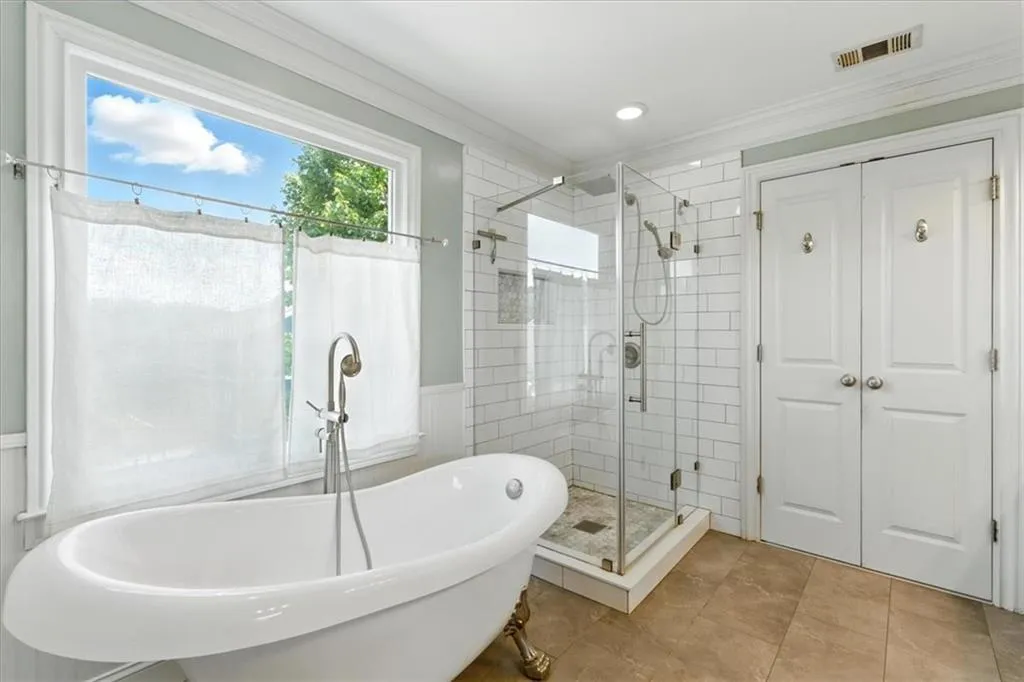 Full bathroom featuring ornamental molding, a soaking tub, a shower stall, tile patterned flooring, and recessed lighting