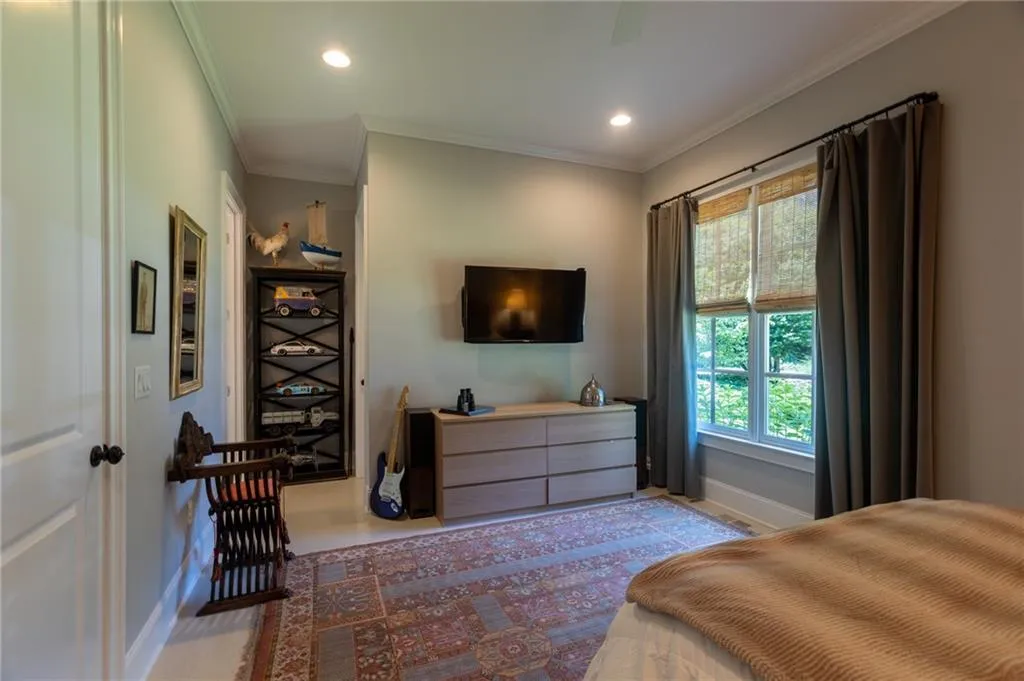 Bedroom with ceiling fan, multiple windows, and crown molding