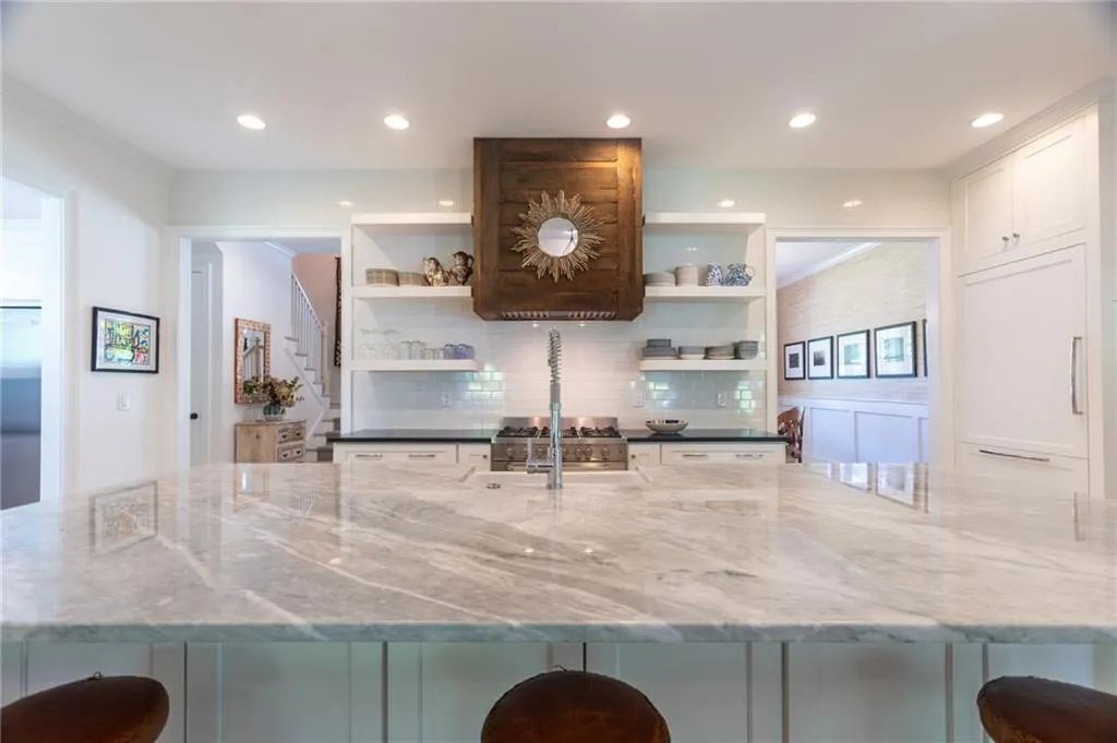 Kitchen with backsplash, white cabinets, a center island, and sink