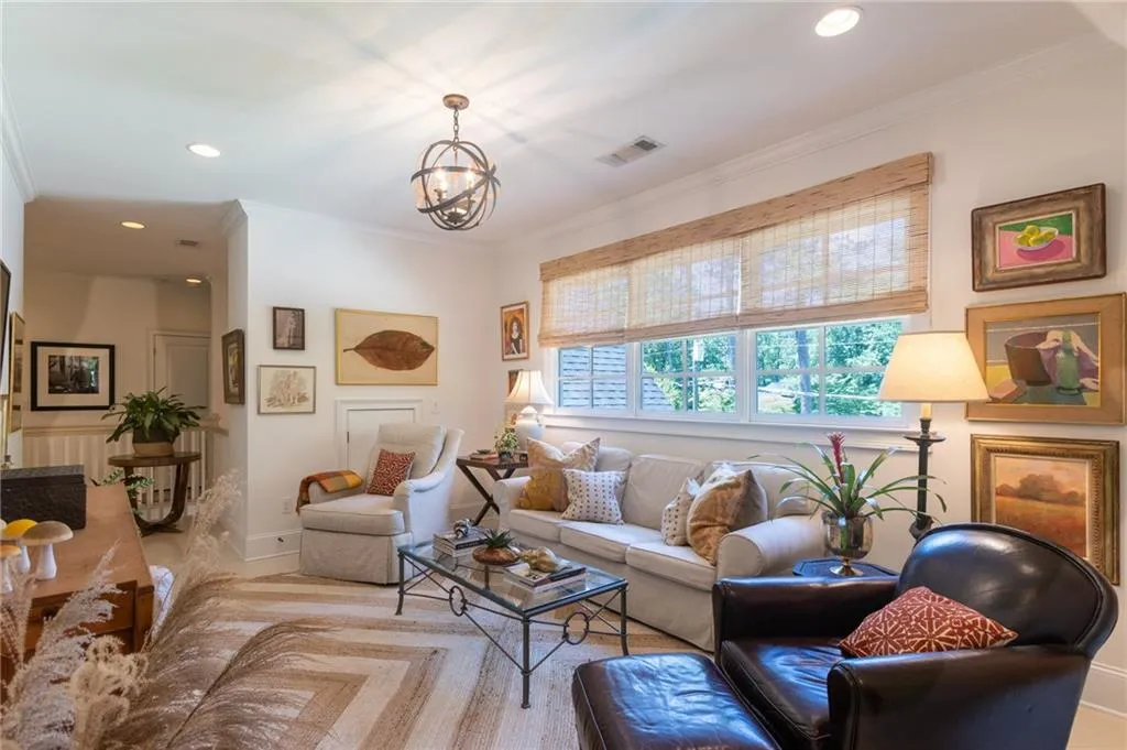 Living room featuring crown molding and a notable chandelier