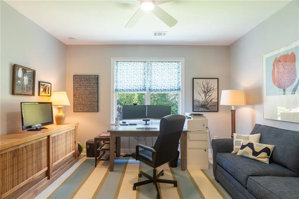 Office with ceiling fan and light carpet