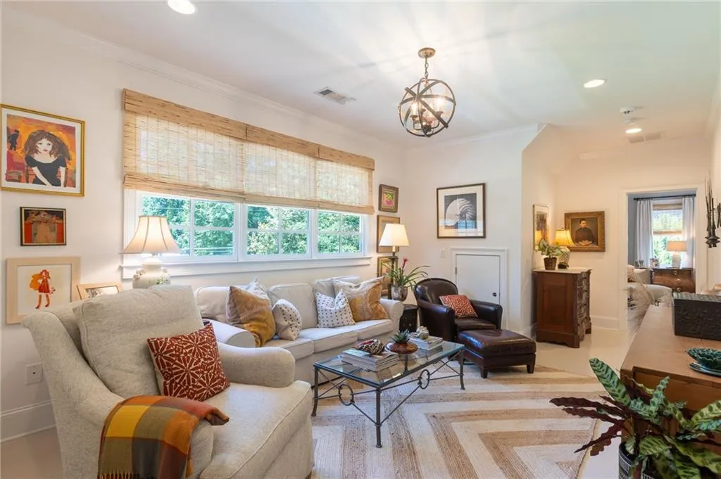 Living room featuring ornamental molding and an inviting chandelier