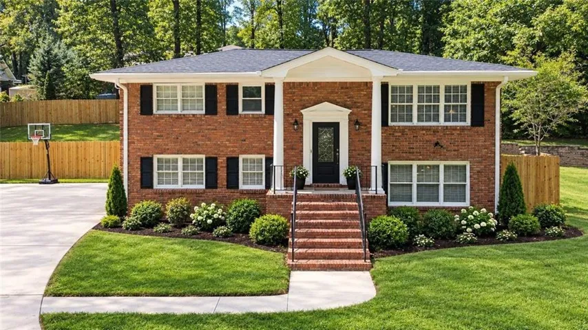 Brick exterior with white window frames and black shutters