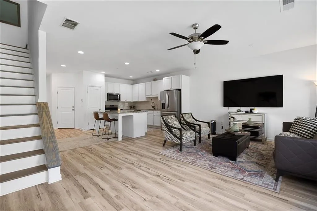 Living room featuring recessed lighting, light wood finished floors, and a ceiling fan