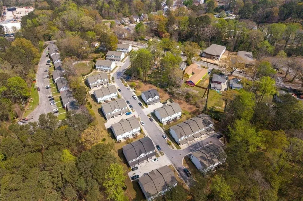 Aerial view of property and surrounding area featuring nearby suburban area