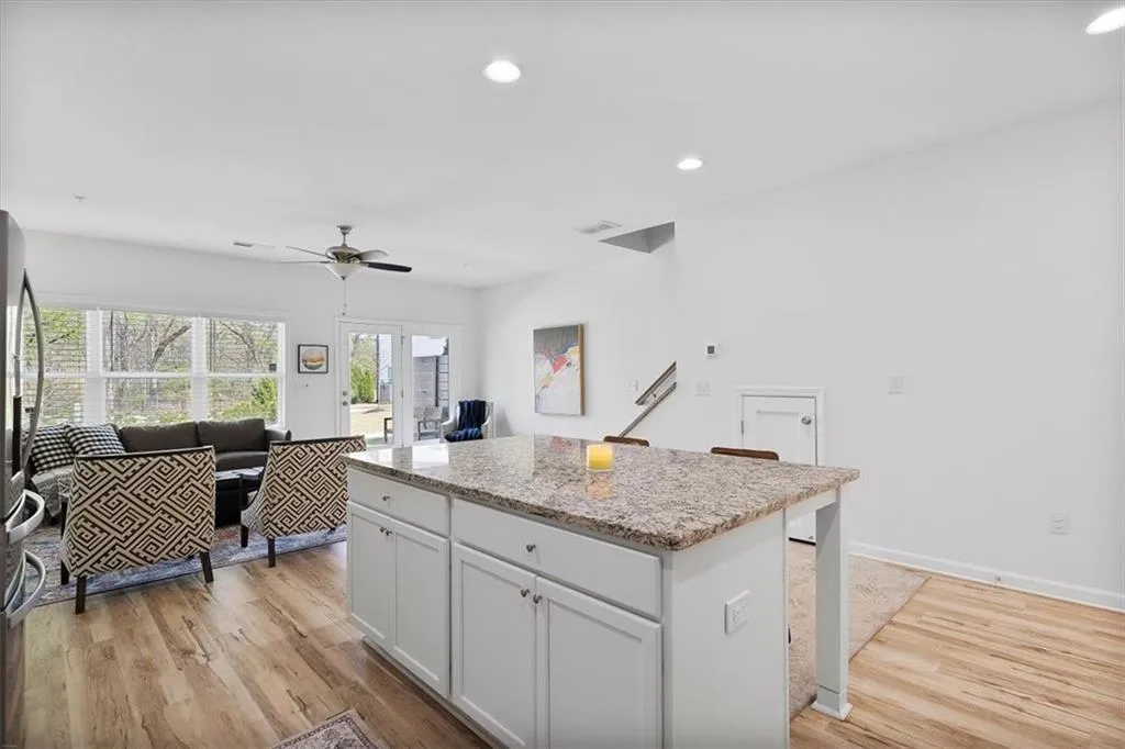 Kitchen featuring a center island, white cabinetry, recessed lighting, light wood-style flooring, and open floor plan
