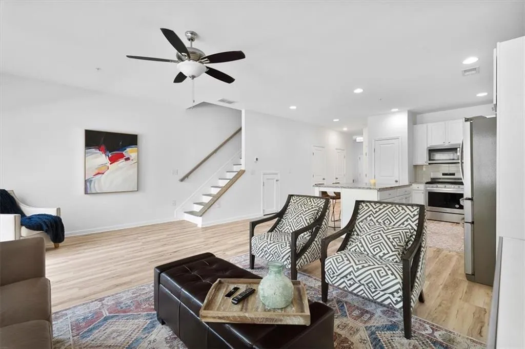 Living area featuring a ceiling fan, light wood-style flooring, and recessed lighting