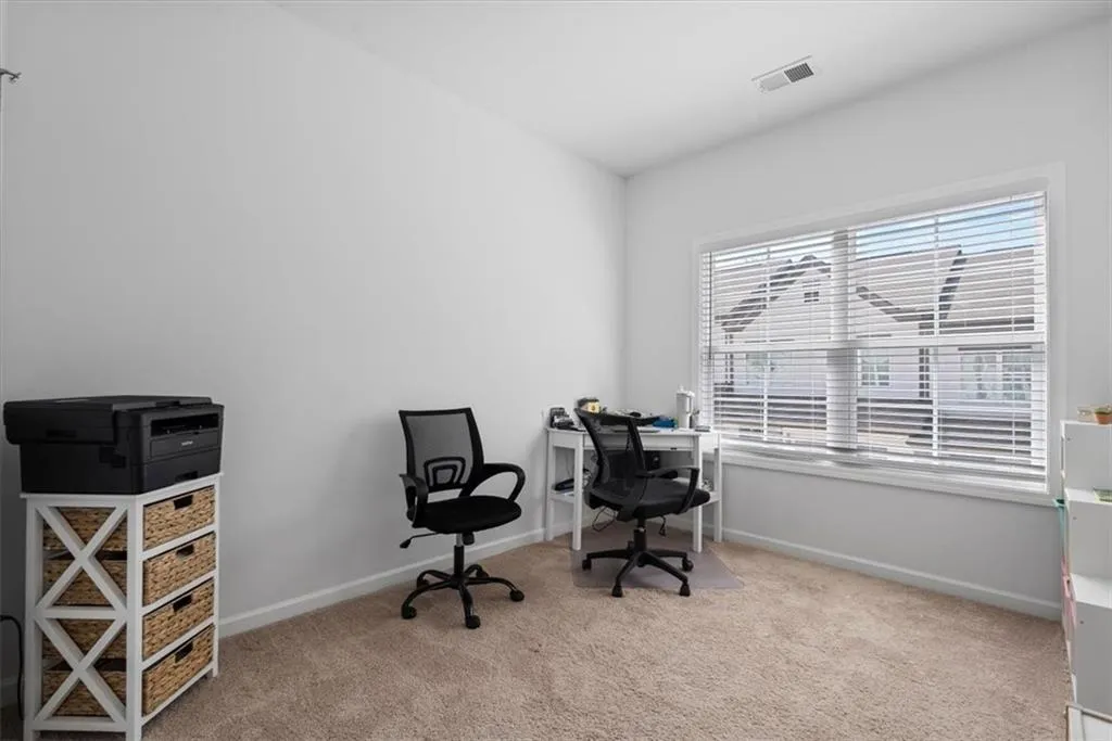 Home office featuring light colored carpet and baseboards