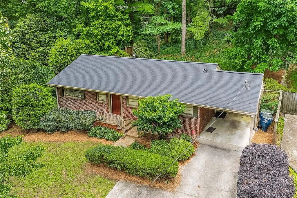 View of front of property featuring brick siding, concrete driveway, an attached carport, and a porch