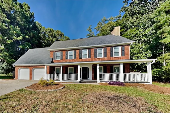 Brick exterior with white columns and railing