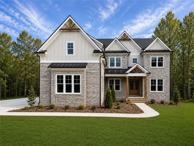 Traditional style home featuring a light gray brick exterior, dark asphalt shingle roof, and board and batten gables