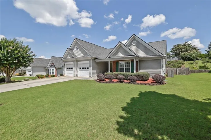 Charming single-family residence featuring a gabled roofline with multiple peaks, vinyl siding exterior, and a two-car garage